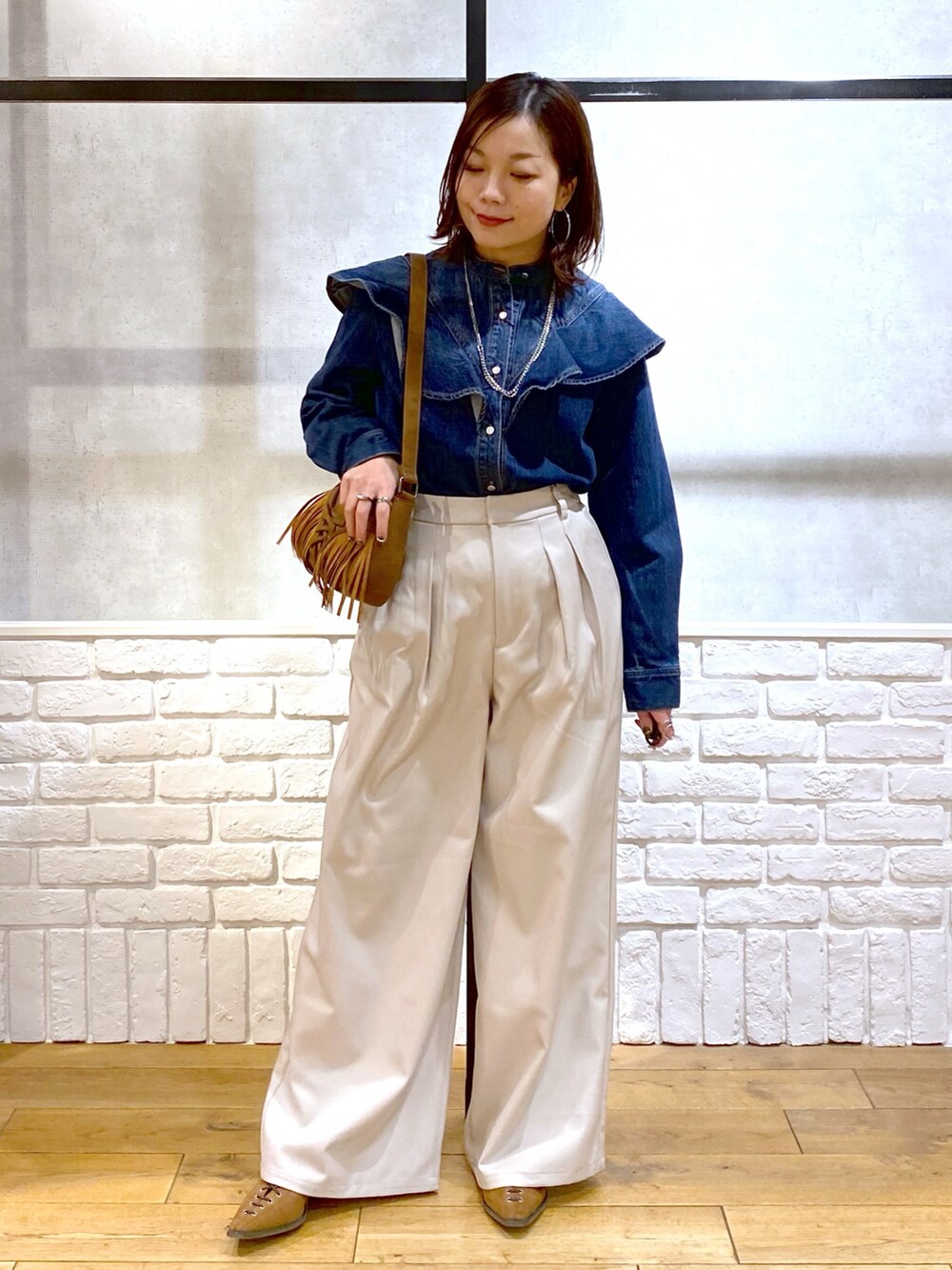 ブルー系のシャツ/ブラウス、ベージュ系のショルダーバッグ、ベージュ系のスラックスを着用したレディースの春コーディネートの8枚目の写真