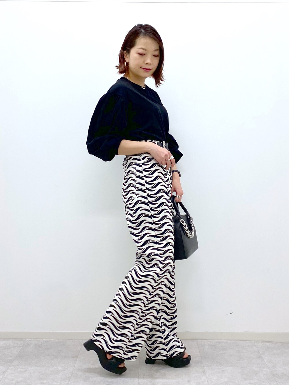 ホワイト系のその他パンツ、ブラック系のショルダーバッグ、ブラック系のTシャツ/カットソーを着用したレディースの春コーディネートの3枚目の写真