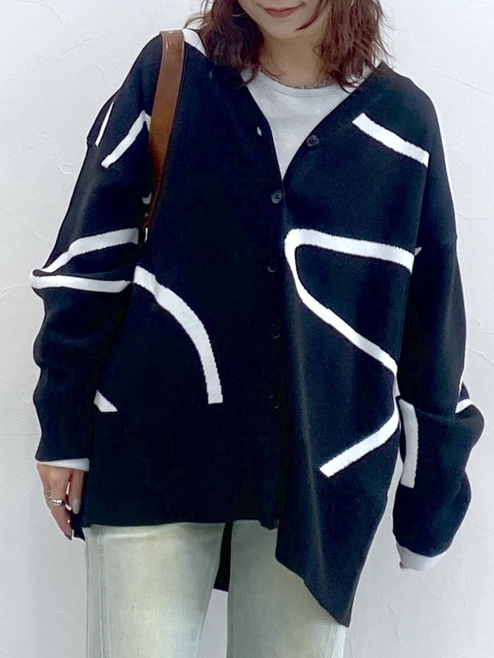 ホワイト系のTシャツ/カットソー、ブルー系のデニムパンツ、ブラック系のカーディガン/ボレロを着用したレディースの秋コーディネートの2枚目の写真