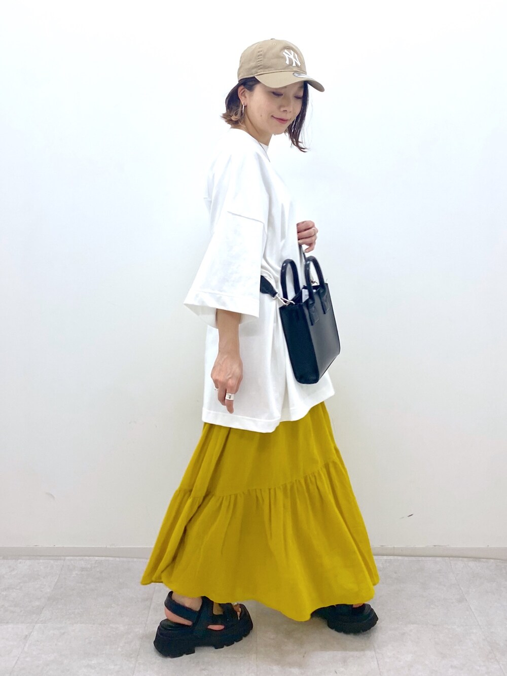 ホワイト系のTシャツ/カットソー、ブラック系のショルダーバッグ、ブラック系のサンダルを着用したレディースの夏コーディネートの2枚目の写真