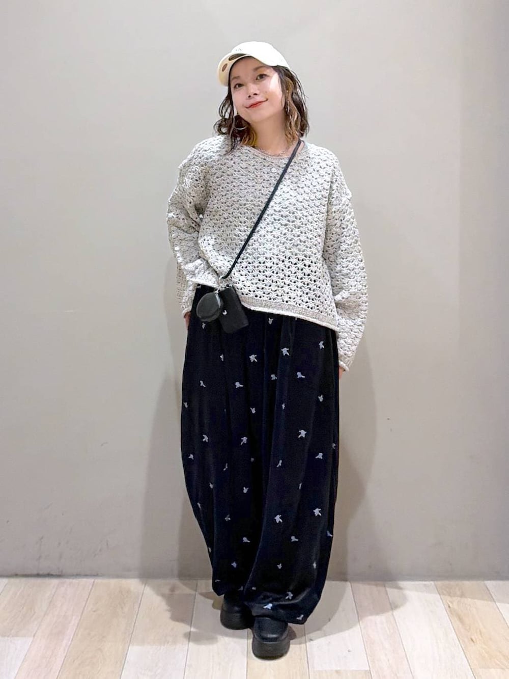 ブラック系のその他パンツ、ブラック系のブーツ、ホワイト系のニット/セーターを着用したレディースの秋コーディネートの9枚目の写真