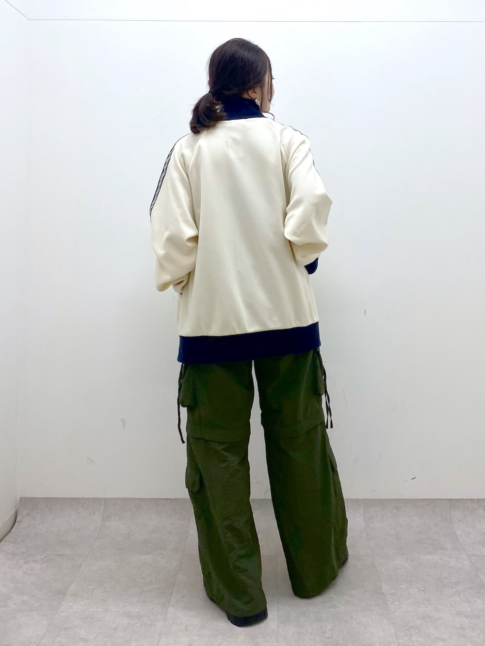 ブラック系のキャミソール、ホワイト系のセットアップ、グリーン系のカーゴパンツを着用したレディースの冬コーディネートの6枚目の写真