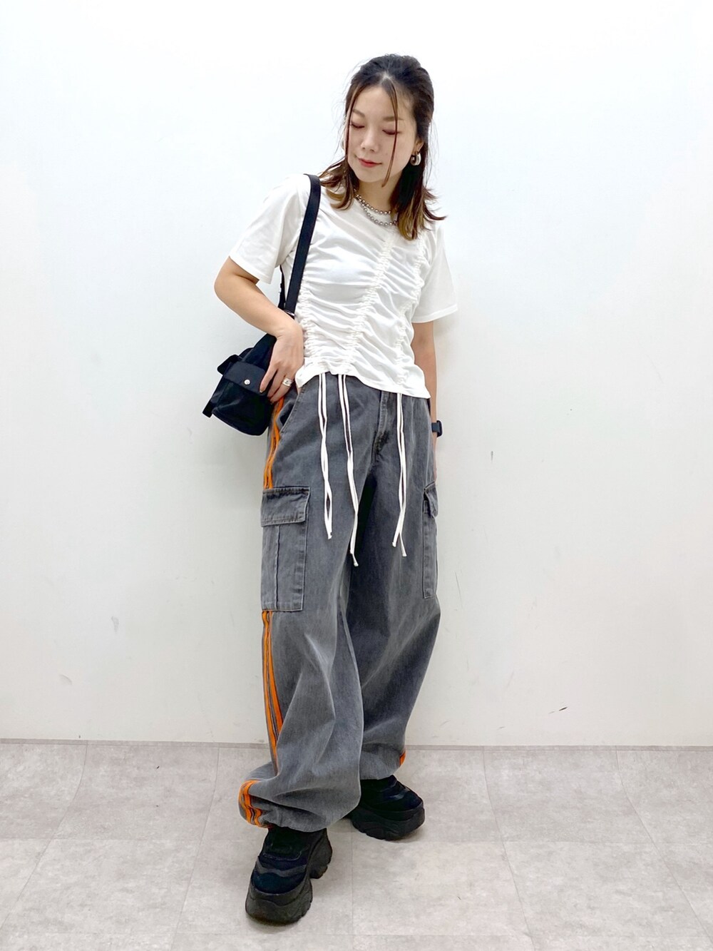 ホワイト系のTシャツ/カットソー、ブラック系のデニムパンツ、ブラック系のスニーカーを着用したレディースの春コーディネートの8枚目の写真