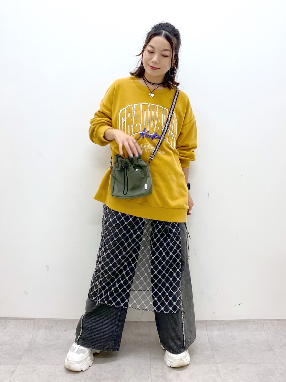イエロー系のスウェット、ブラック系のデニムパンツ、ホワイト系のスニーカーを着用したレディースの夏コーディネートの8枚目の写真