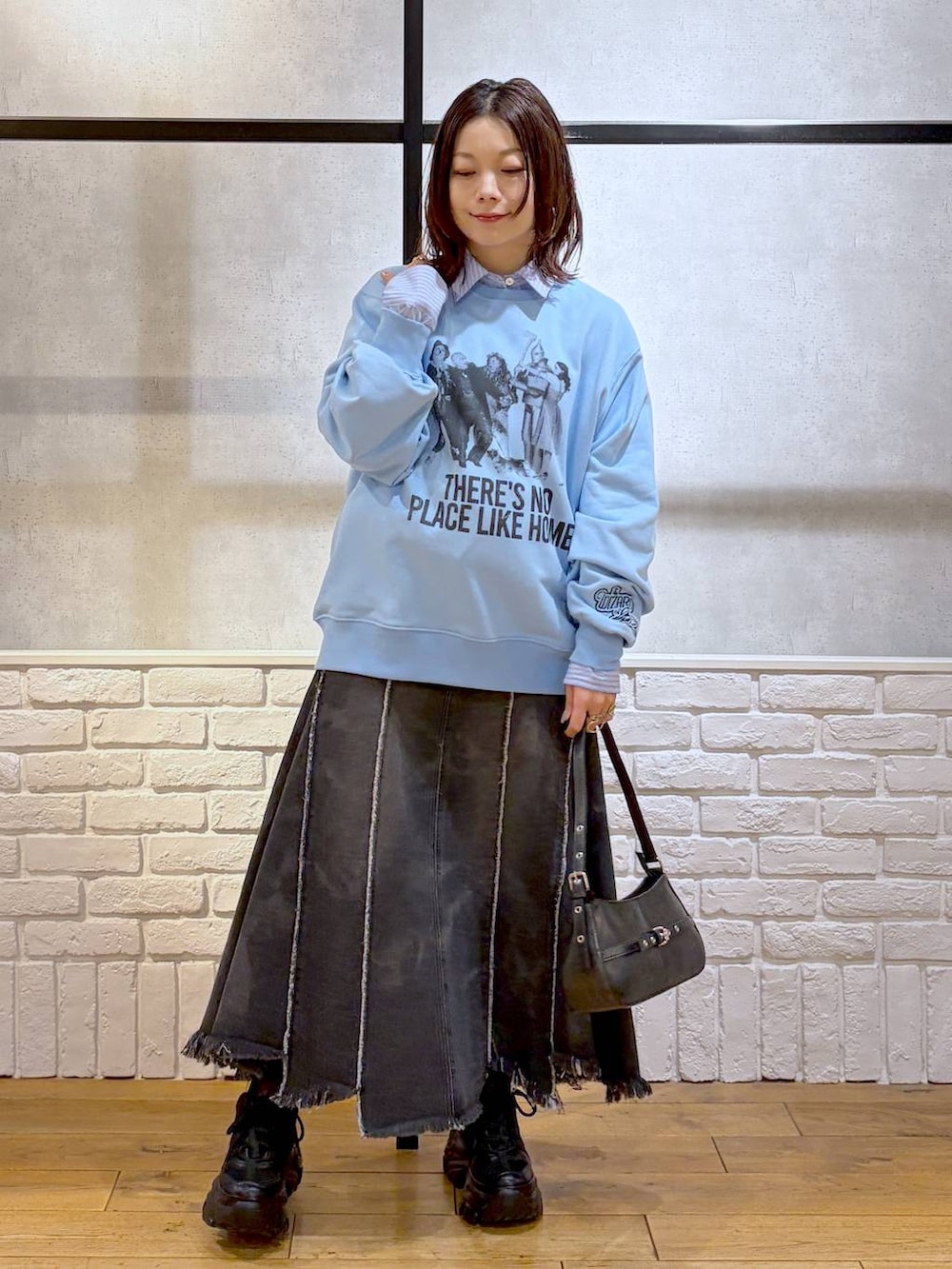 ブラック系のスニーカー、ブラック系のハンドバッグ、ブラック系のデニムスカートを着用したレディースの春コーディネートの8枚目の写真