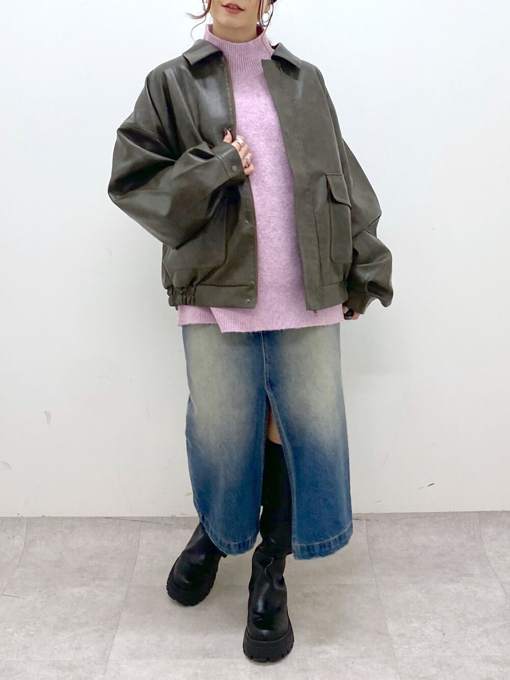 レッド系のニット/セーター、ブルー系のスカート、ブラック系のブーツを着用したレディースの秋コーディネートの5枚目の写真