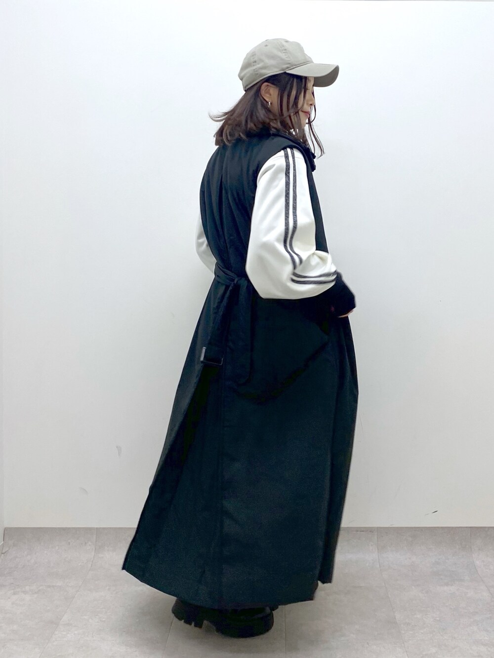 ブラック系のベスト、ブラック系のブーツ、ホワイト系のジャージを着用したレディースの秋コーディネートの5枚目の写真