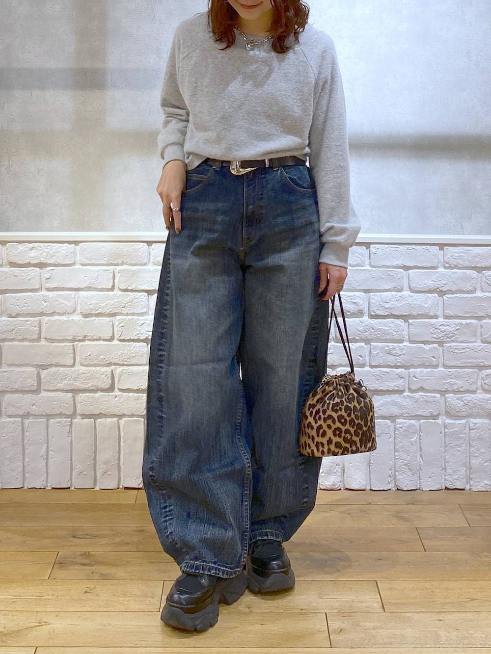 ブラック系のブーツ、ブルー系のデニムパンツ、その他のハンドバッグを着用したレディースの冬コーディネートの3枚目の写真