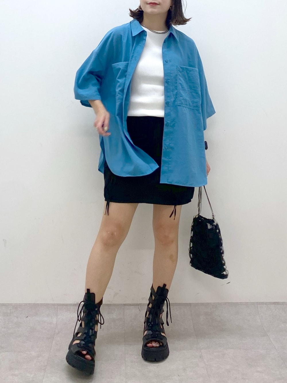 ブルー系のシャツ/ブラウス、ホワイト系のタンクトップ、ブラック系のスカートを着用したレディースの夏コーディネートの3枚目の写真