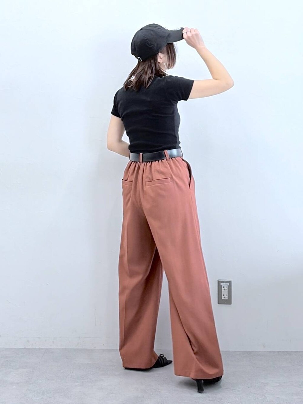 ブラウン系のスラックス、ブラック系のTシャツ/カットソー、ブラック系のキャップを着用したレディースの春コーディネートの5枚目の写真