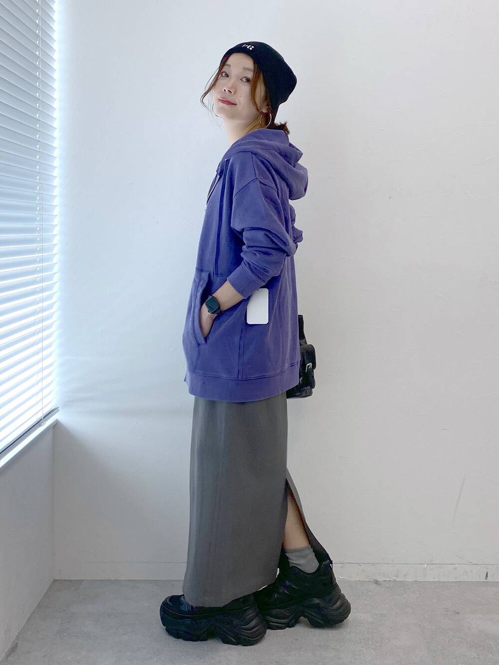 ブラック系のスニーカー、グレー系のスカート、ブラック系のショルダーバッグを着用したレディースの秋コーディネートの6枚目の写真