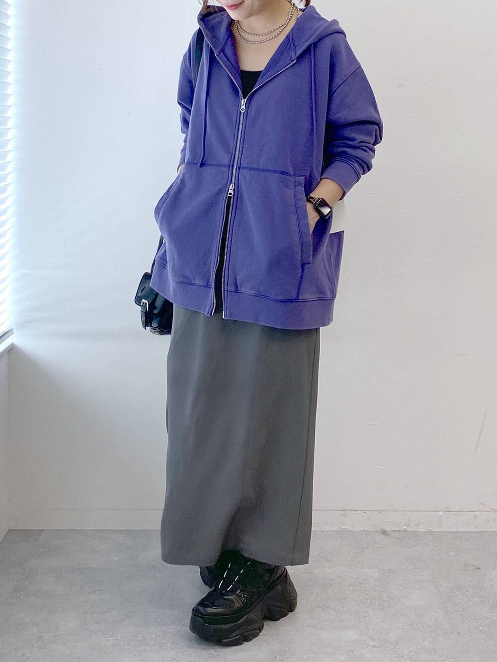 ブラック系のスニーカー、グレー系のスカート、ブラック系のショルダーバッグを着用したレディースの秋コーディネートの3枚目の写真