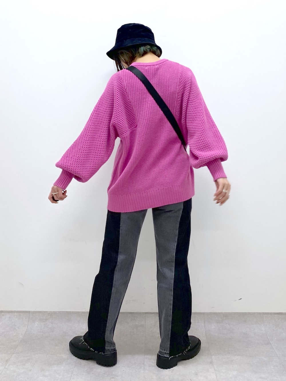 ブラック系のショルダーバッグ、ピンク系のニット/セーター、ブラック系のパンツを着用したレディースの冬コーディネートの3枚目の写真