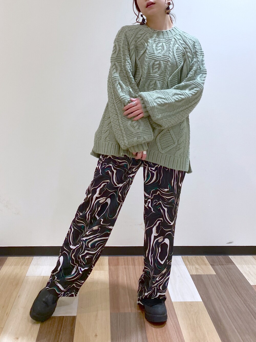 グリーン系のニット/セーター、ブラック系のその他パンツ、ブラック系のブーツを着用したレディースの冬コーディネートの3枚目の写真