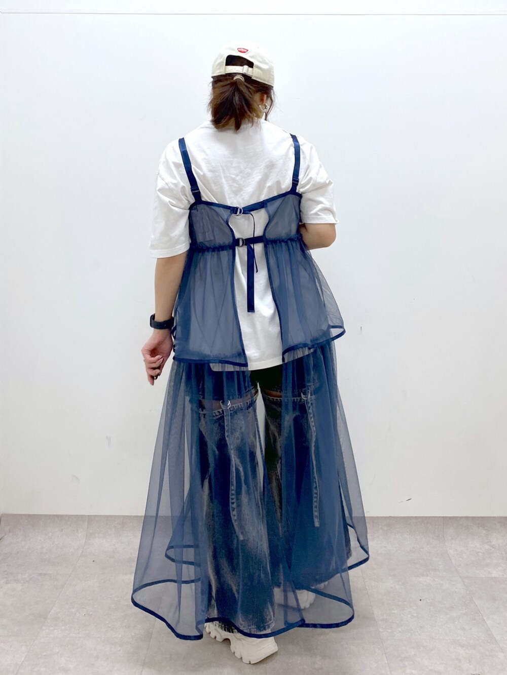 ホワイト系のTシャツ/カットソー、ブルー系のワンピース、ブラック系のデニムパンツを着用したレディースの春コーディネートの5枚目の写真