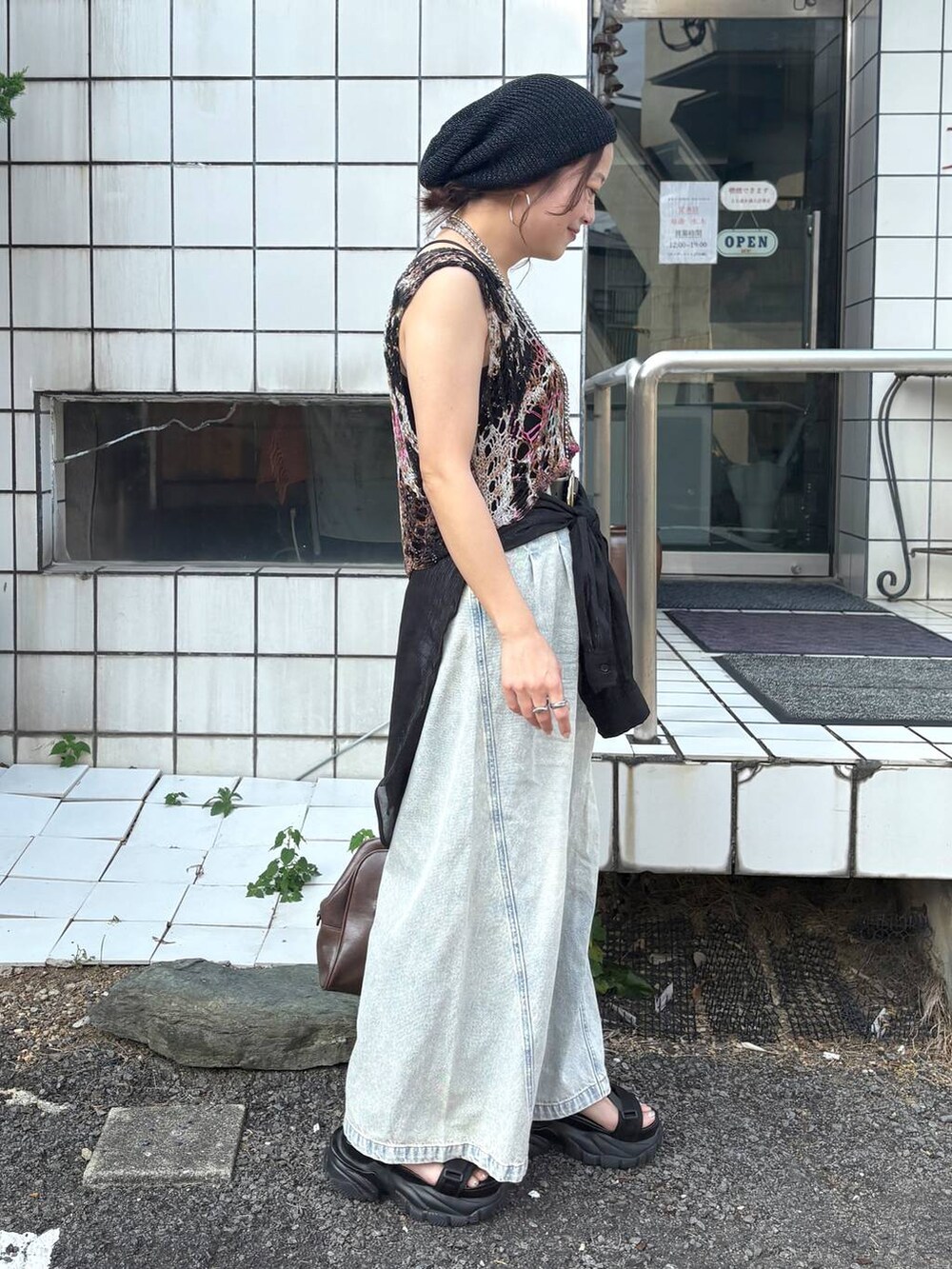 ブルー系のデニムパンツ、その他のベスト、ブラウン系のボストンバッグを着用したレディースの夏コーディネートの3枚目の写真
