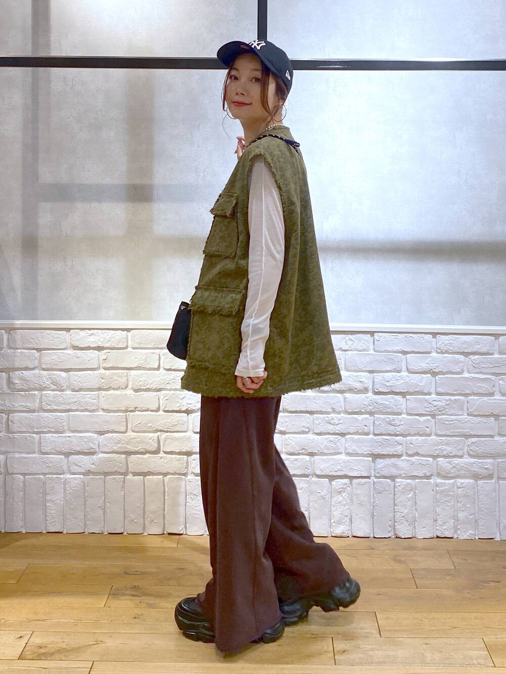 ブラック系のスニーカー、ブラウン系のスウェットパンツ、ブラック系のショルダーバッグを着用したレディースの夏コーディネートの5枚目の写真