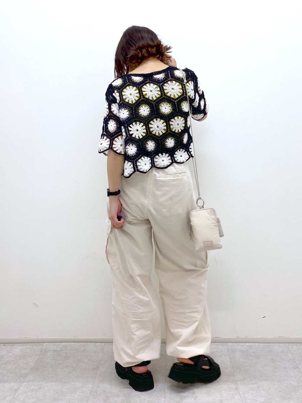 ホワイト系のカーゴパンツ、イエロー系のタンクトップ、ブラック系のトップスを着用したレディースの夏コーディネートの4枚目の写真