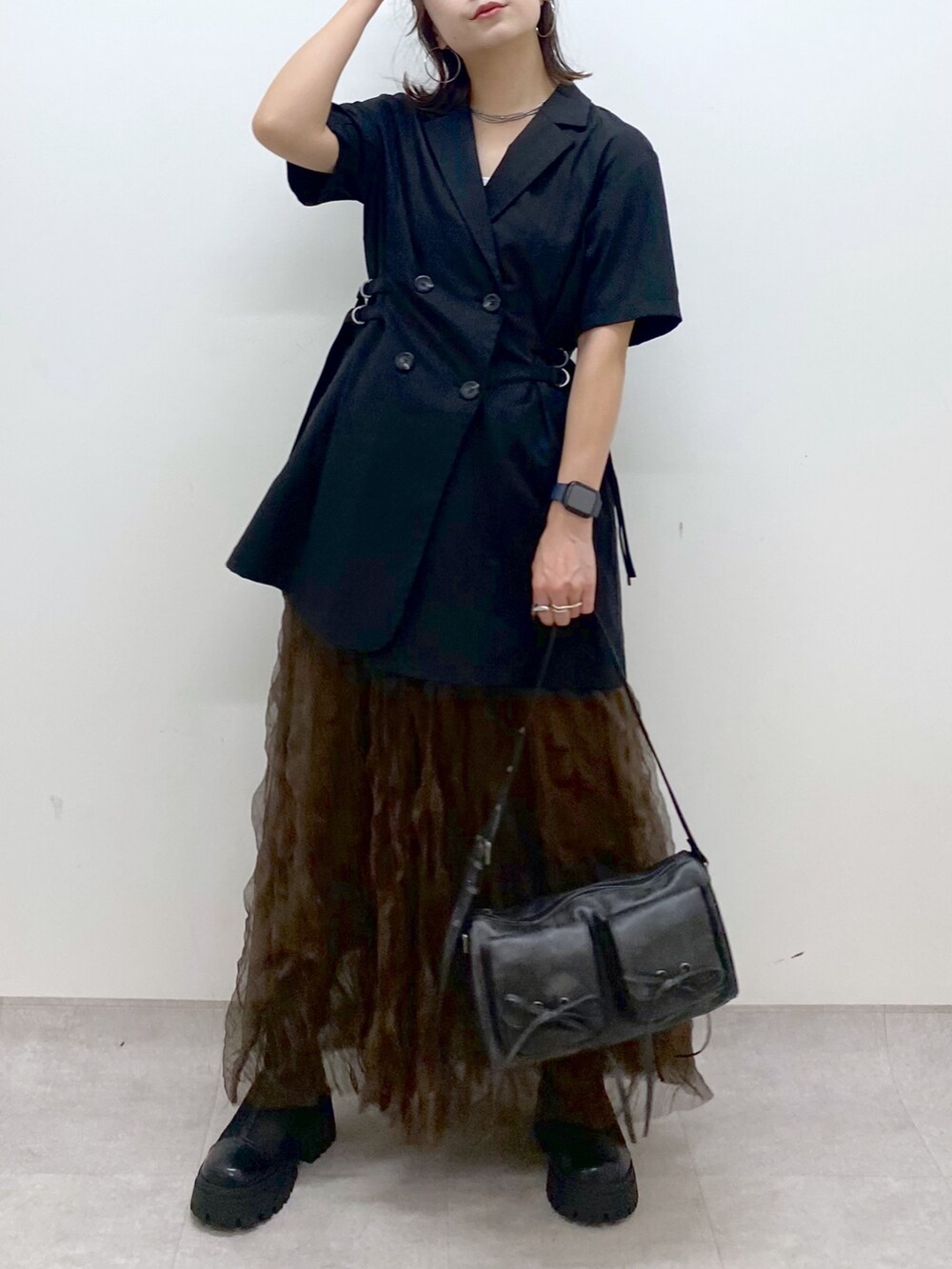 ブラック系のテーラードジャケット、ブラウン系のスカート、ブラック系のショルダーバッグを着用したレディースの夏コーディネートの3枚目の写真