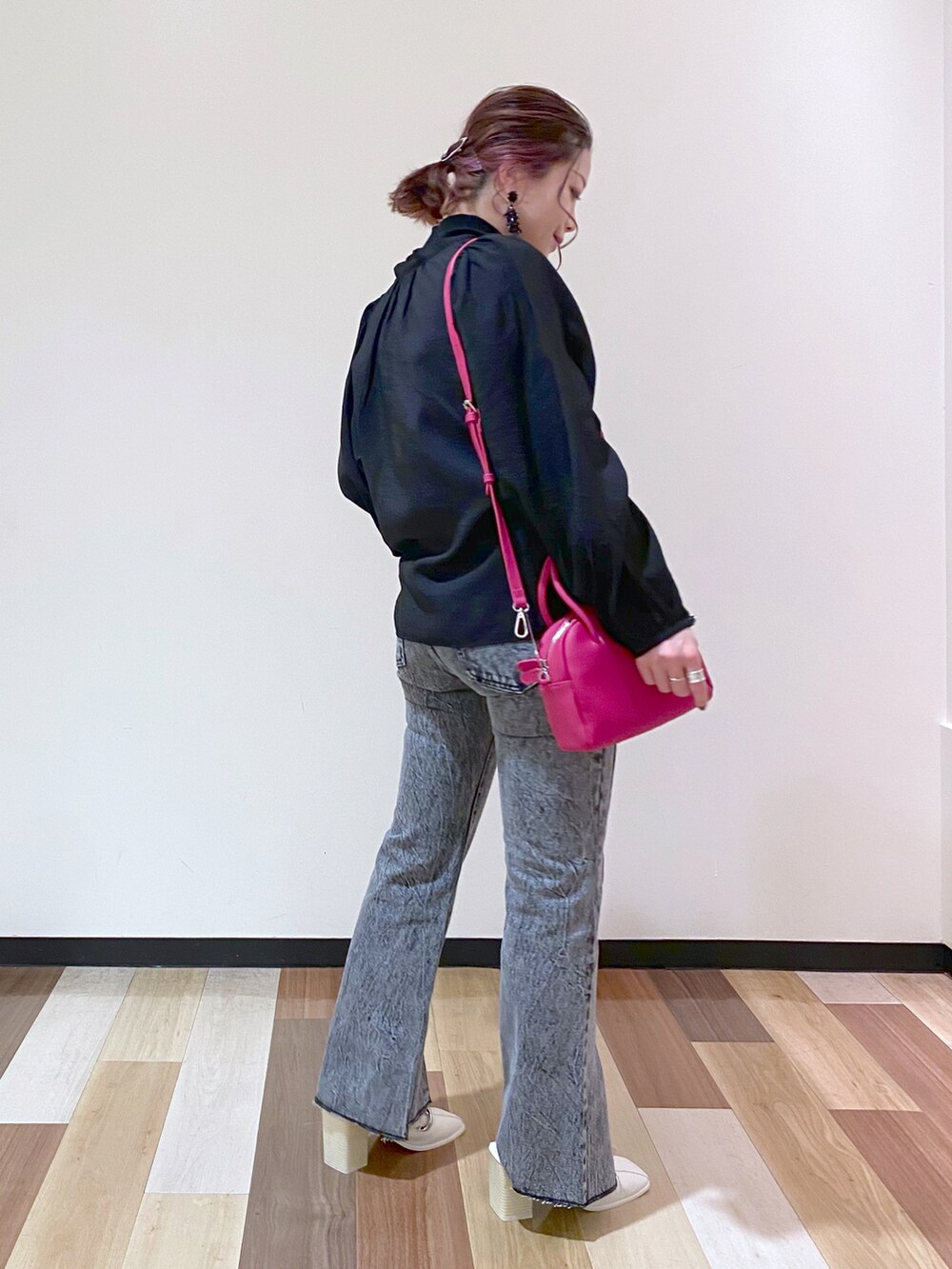 ブラック系のデニムパンツ、ホワイト系のサンダル、ピンク系のボストンバッグを着用したレディースの冬コーディネートの3枚目の写真