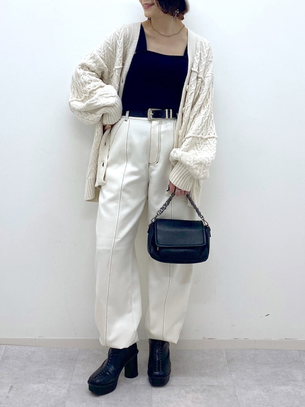 ホワイト系のその他パンツ、ブラック系のバッグ、ブラック系のブーツを着用したレディースの秋コーディネートの4枚目の写真