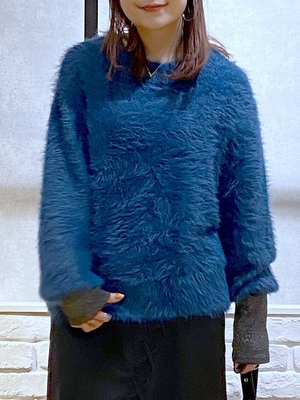 シルバー系のTシャツ/カットソー、ブラック系のブーツ、ブルー系のニット/セーターを着用したレディースの冬コーディネートの2枚目の写真