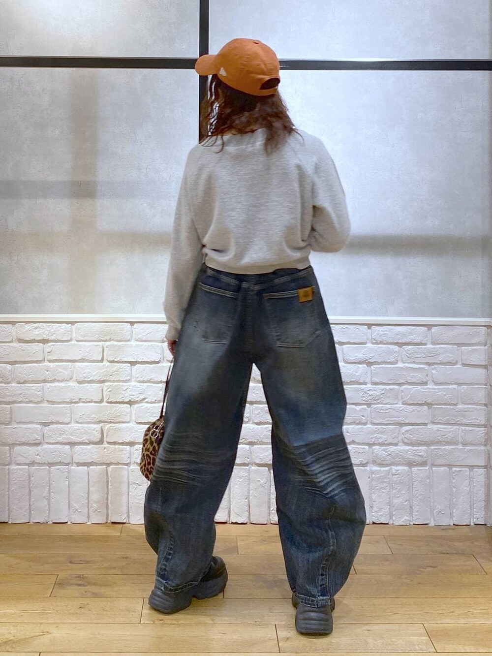 ブラック系のブーツ、ブルー系のデニムパンツ、その他のハンドバッグを着用したレディースの冬コーディネートの6枚目の写真