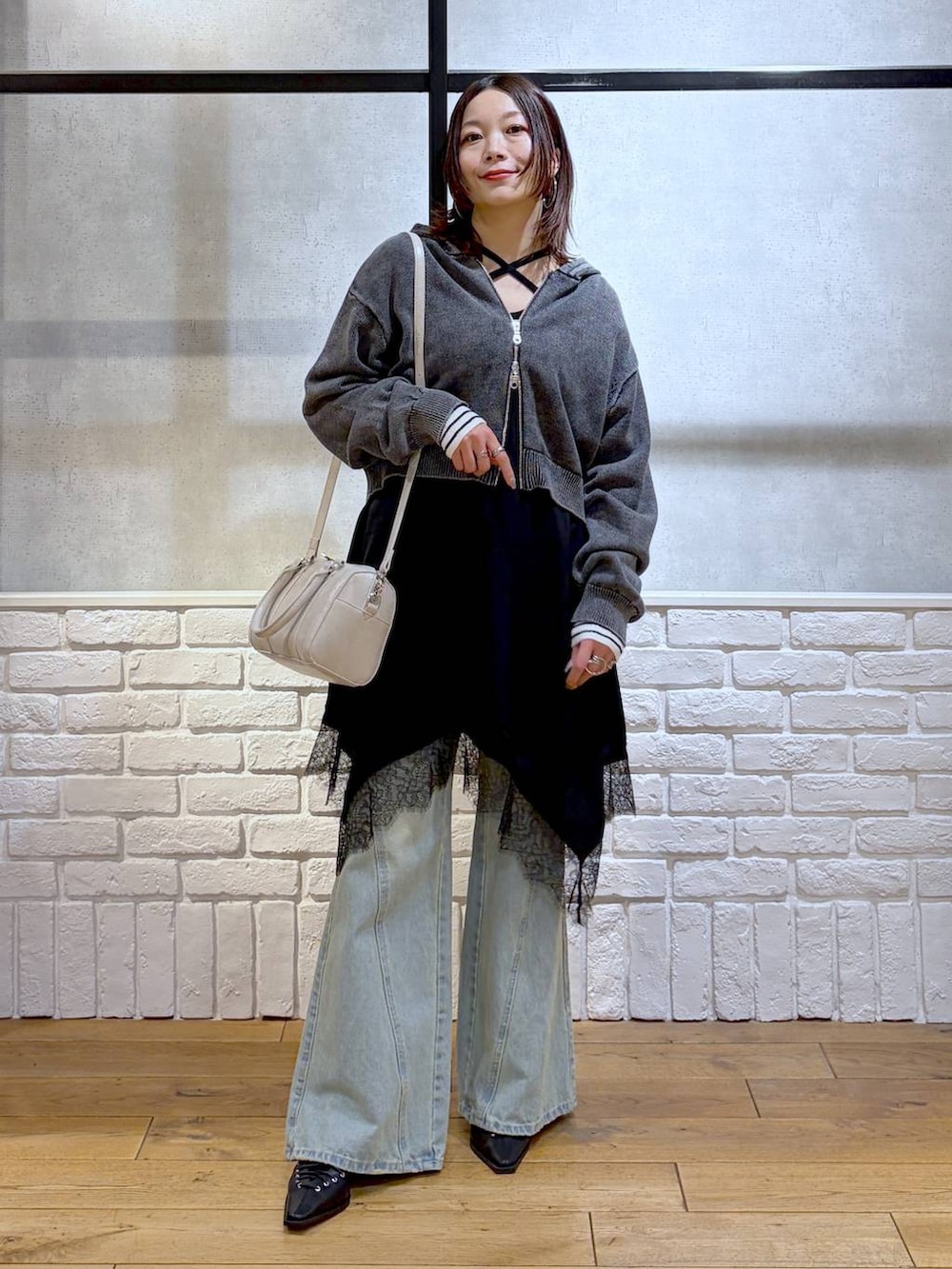 ブルー系のデニムパンツ、ホワイト系のボストンバッグ、ホワイト系のニット/セーターを着用したレディースの春コーディネートの9枚目の写真