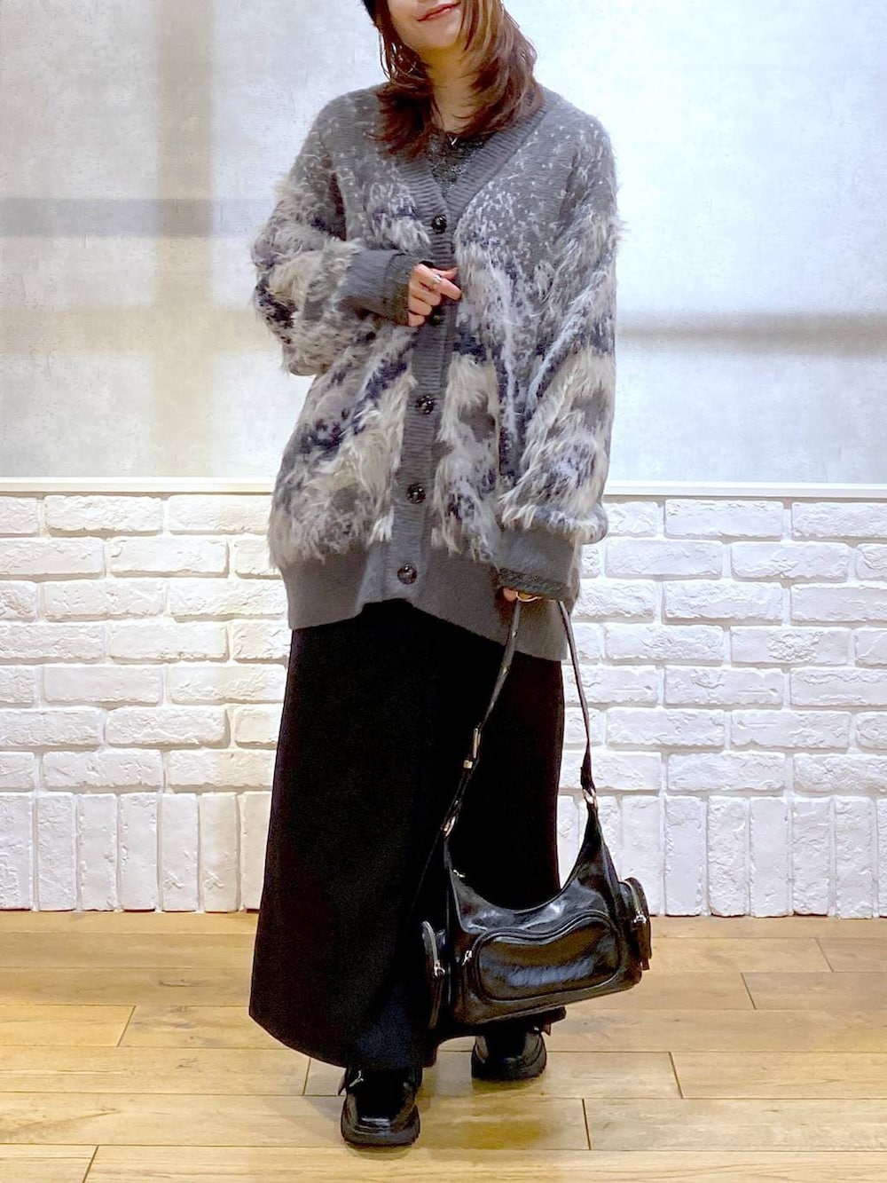 シルバー系のTシャツ/カットソー、ブラック系のブーツ、ブラック系のスカートを着用したレディースの冬コーディネートの3枚目の写真