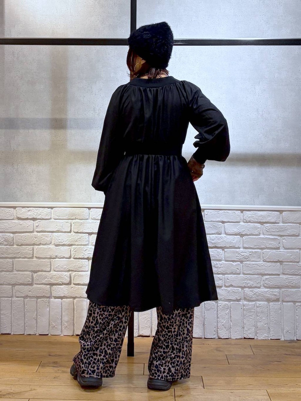 ブラック系のブーツ、ベージュ系のその他パンツ、ブラック系のワンピースを着用したレディースの冬コーディネートの6枚目の写真