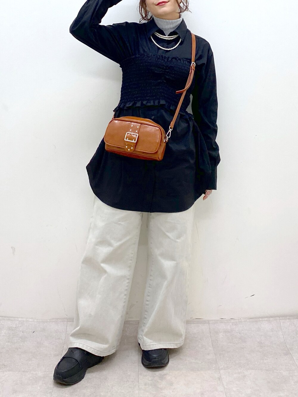 ブラック系のシャツ/ブラウス、ベージュ系のショルダーバッグ、グレー系のデニムパンツを着用したレディースの冬コーディネートの3枚目の写真