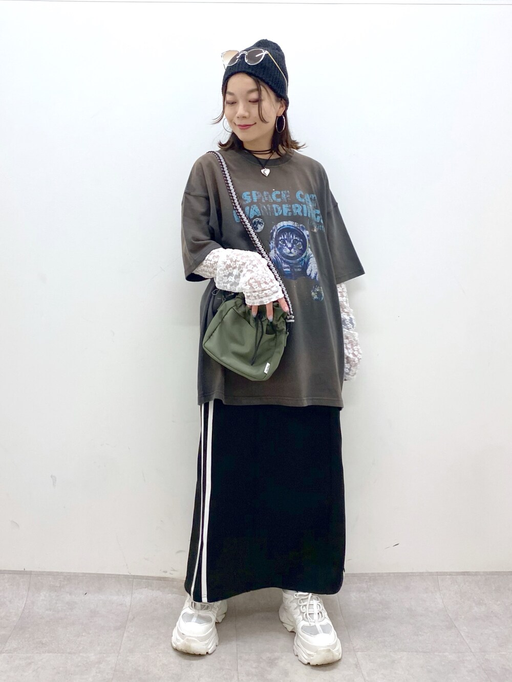 グレー系のTシャツ/カットソー、ブラック系のスカート、ホワイト系のスニーカーを着用したレディースの夏コーディネートの8枚目の写真