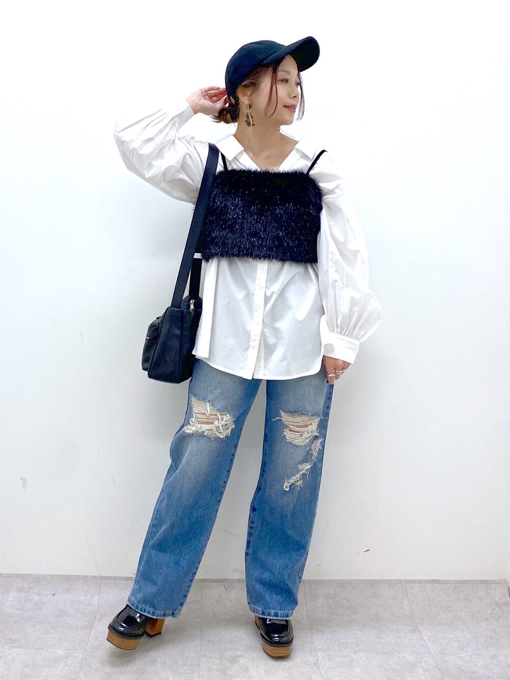 ブルー系のデニムパンツ、ホワイト系のシャツ/ブラウス、ブラック系のベストを着用したレディースの秋コーディネートの2枚目の写真