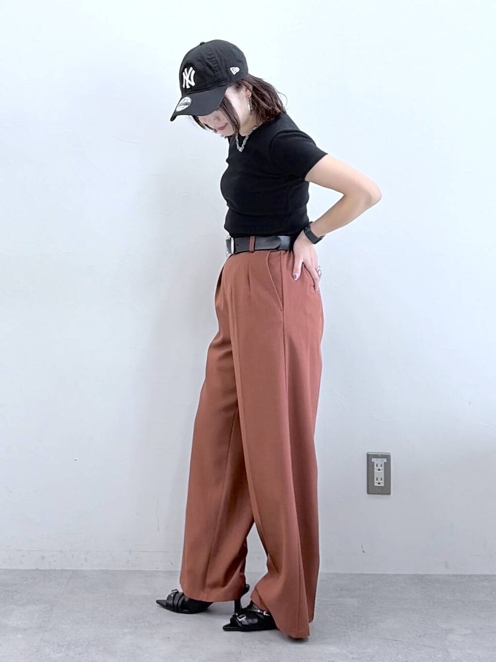 ブラウン系のスラックス、ブラック系のTシャツ/カットソー、ブラック系のキャップを着用したレディースの春コーディネートの7枚目の写真