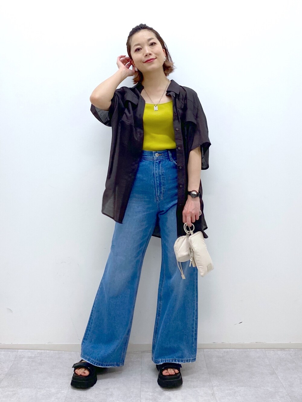 ブルー系のパンツ、イエロー系のタンクトップ、ベージュ系のショルダーバッグを着用したレディースの夏コーディネートの5枚目の写真