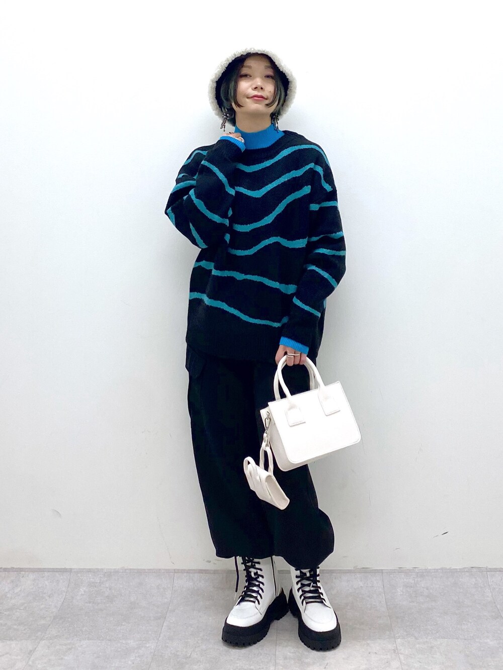 ブラック系のトップス、ブラック系のカーゴパンツ、ホワイト系のバッグを着用したレディースの秋コーディネートの2枚目の写真