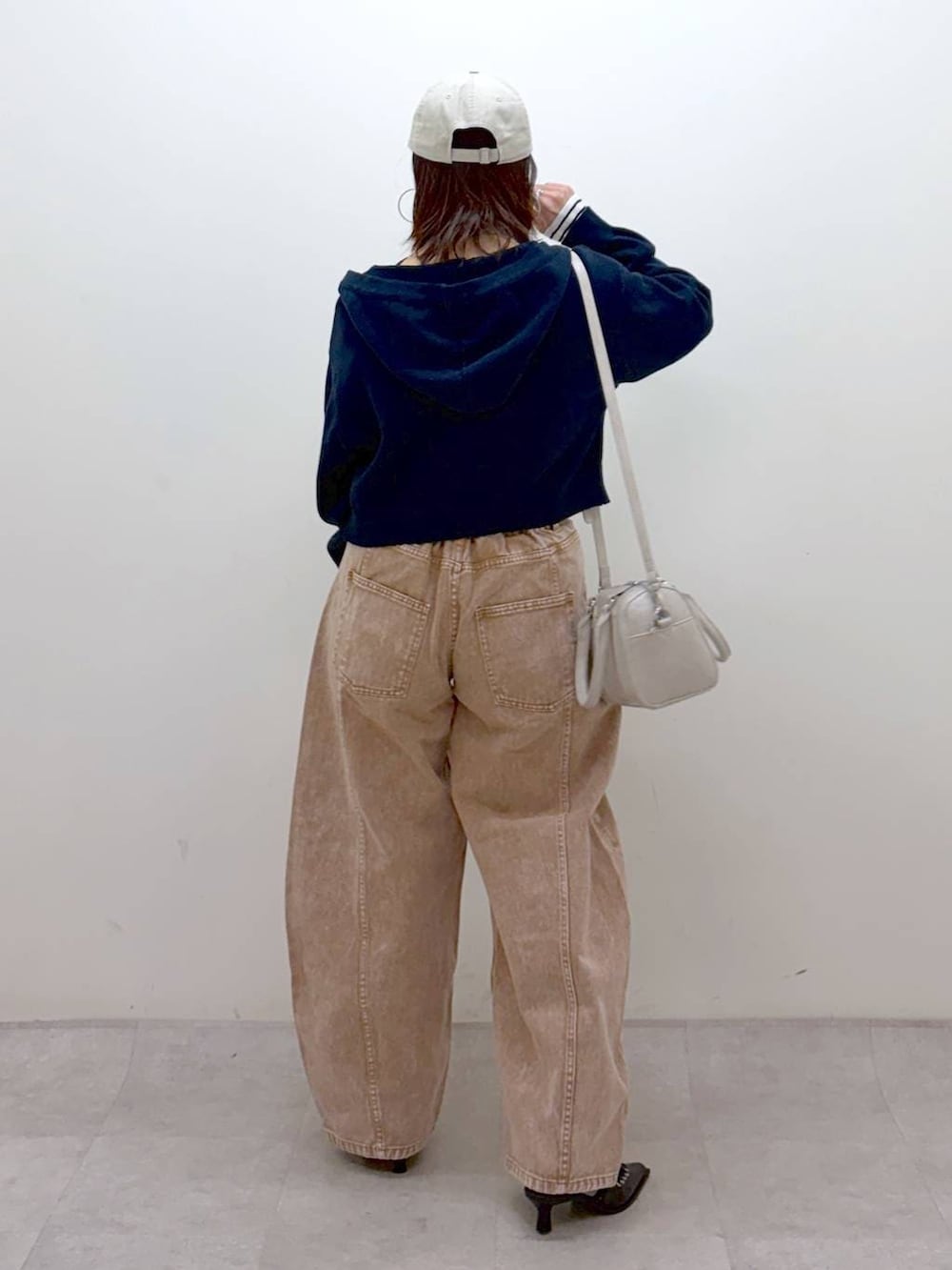 ブラウン系のデニムパンツ、ブラウン系のデニムパンツ、ホワイト系のボストンバッグを着用したレディースの冬コーディネートの5枚目の写真