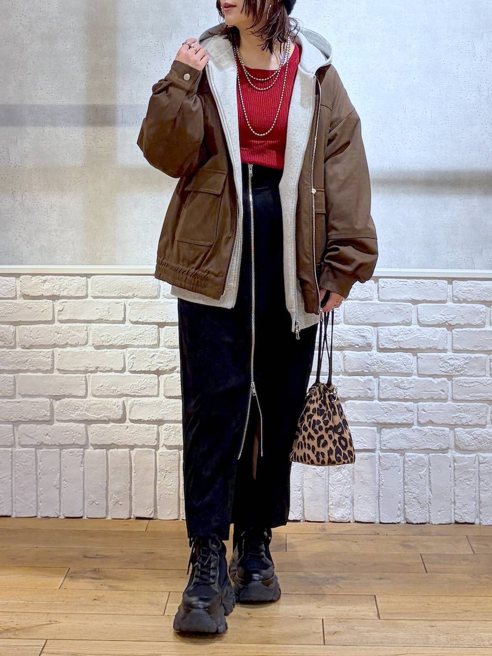 ブラック系のブーツ、ブラウン系のブルゾン、レッド系のニット/セーターを着用したレディースの冬コーディネートの2枚目の写真