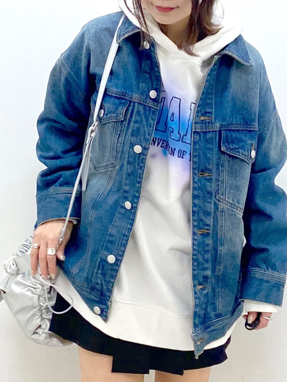 ブルー系のデニムジャケット、シルバー系のショルダーバッグ、ブラック系のその他パンツを着用したレディースの冬コーディネートの2枚目の写真