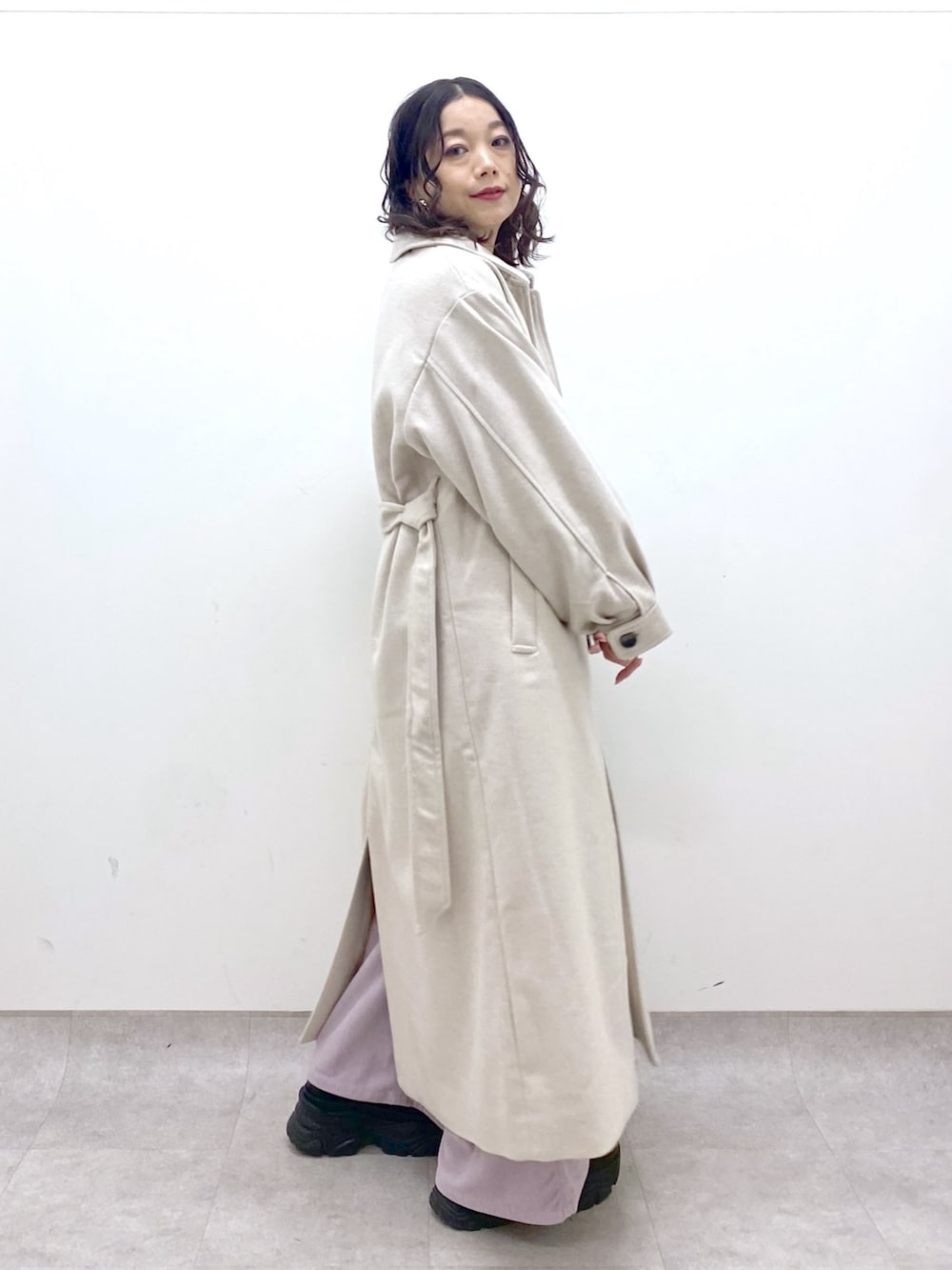 グレー系のチェスターコート、ホワイト系のニット/セーター、ピンク系のカーゴパンツを着用したレディースの冬コーディネートの3枚目の写真