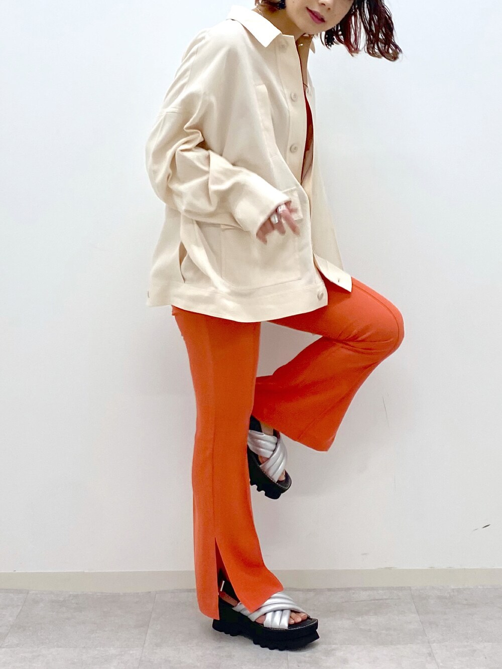 オレンジ系のその他パンツ、シルバー系のサンダル、ベージュ系のミリタリージャケットを着用したレディースの春コーディネートの4枚目の写真