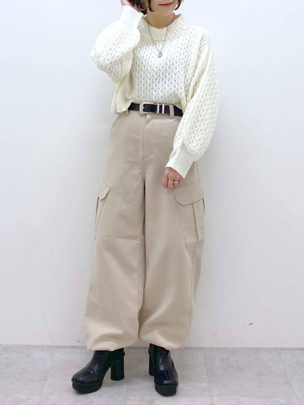 ベージュ系のカーゴパンツ、ホワイト系のニット/セーター、ブラック系のブーツを着用したレディースの冬コーディネートの5枚目の写真