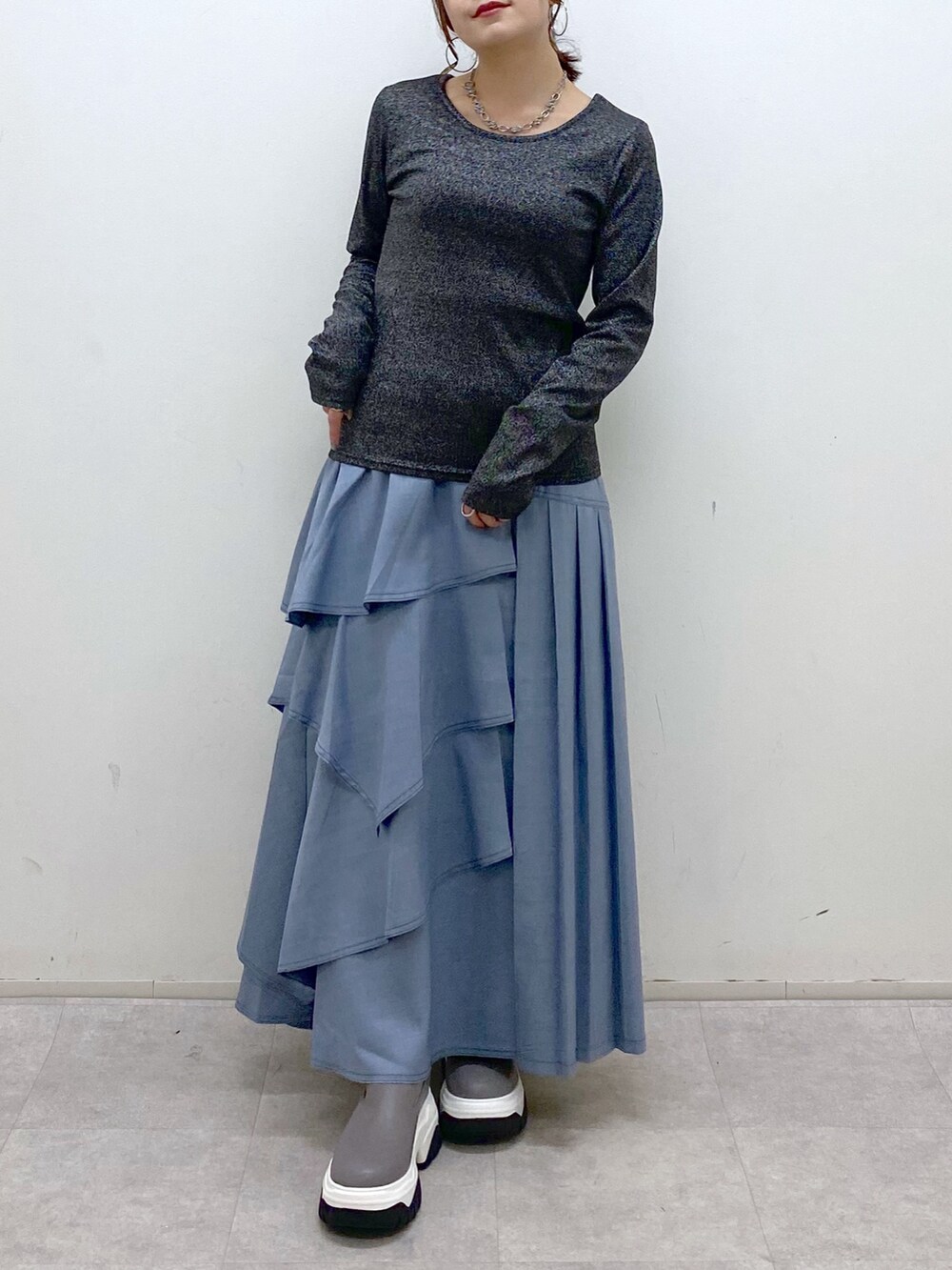 ブラック系のショルダーバッグ、ブルー系のスカート、グレー系のブーツを着用したレディースの秋コーディネートの4枚目の写真