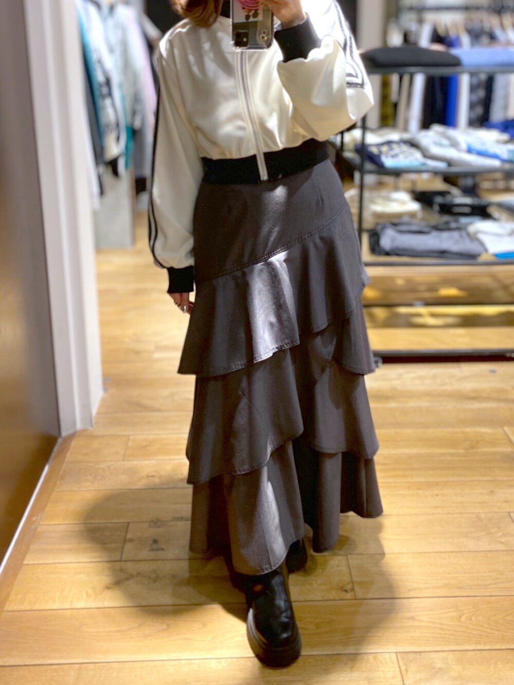 グレー系のスカート、ホワイト系のジャージ、ブラック系のブーツを着用したレディースの冬コーディネートの5枚目の写真