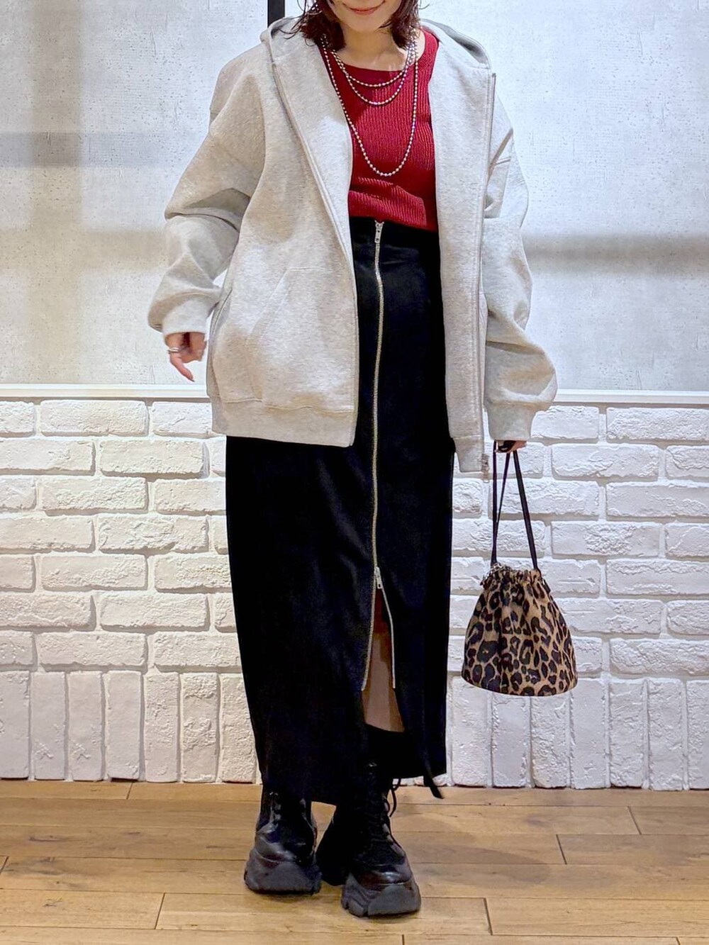 ブラック系のブーツ、ブラウン系のブルゾン、レッド系のニット/セーターを着用したレディースの冬コーディネートの3枚目の写真