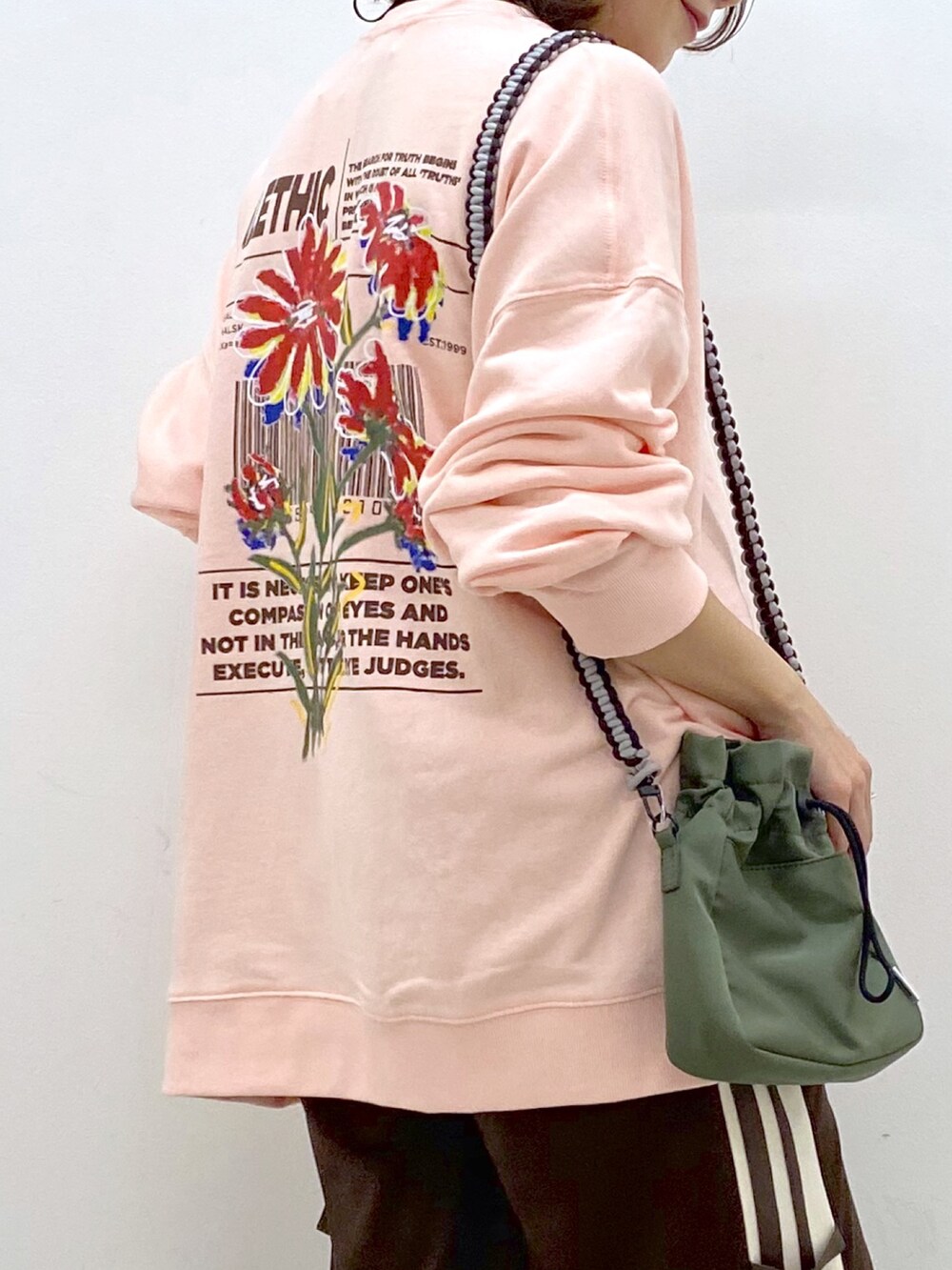 ピンク系のスウェット、グリーン系のショルダーバッグ、ブラウン系のその他パンツを着用したレディースの夏コーディネートの2枚目の写真