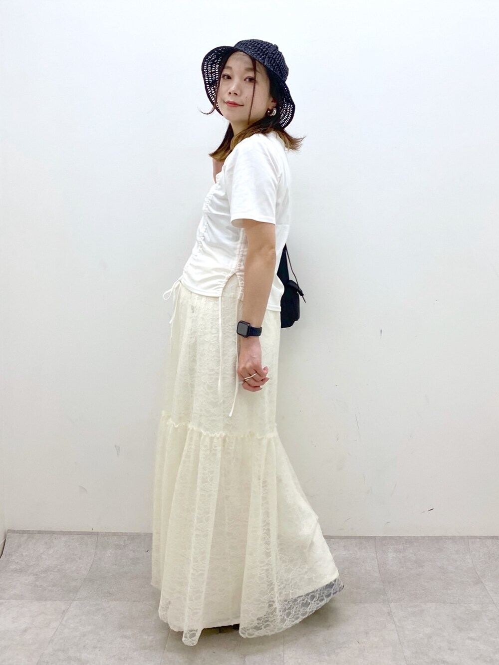 ホワイト系のTシャツ/カットソー、ブラック系のサンダル、ホワイト系のデニムパンツを着用したレディースの春コーディネートの5枚目の写真