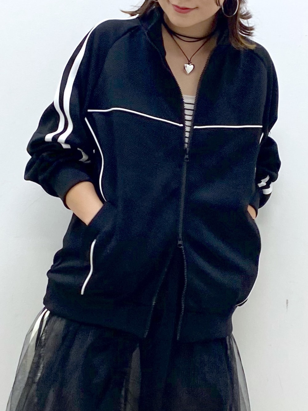 ブラック系のデニムパンツ、ホワイト系のスニーカー、ブラック系のジャージを着用したレディースの夏コーディネートの2枚目の写真