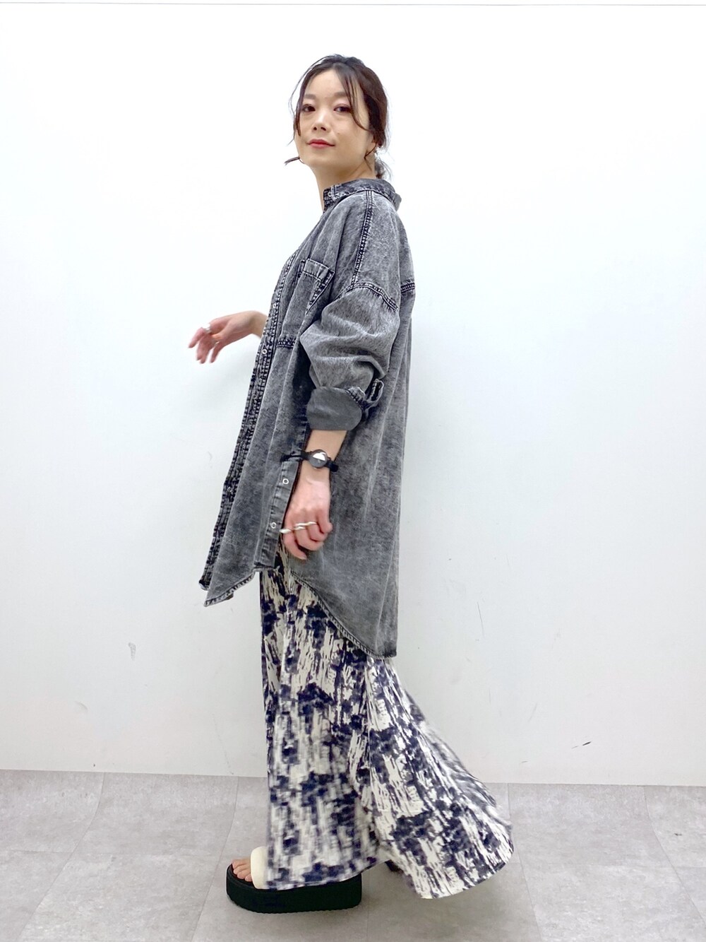 ブラック系のトップス、ブラック系のスカート、ホワイト系のトップスを着用したレディースの春コーディネートの2枚目の写真