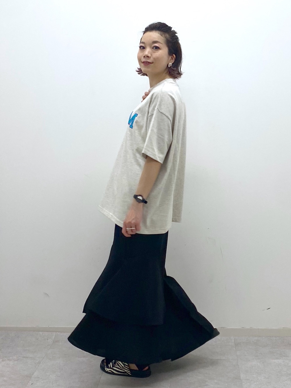 ベージュ系のTシャツ/カットソー、ブラック系のスカート、その他のサンダルを着用したレディースの夏コーディネートの3枚目の写真
